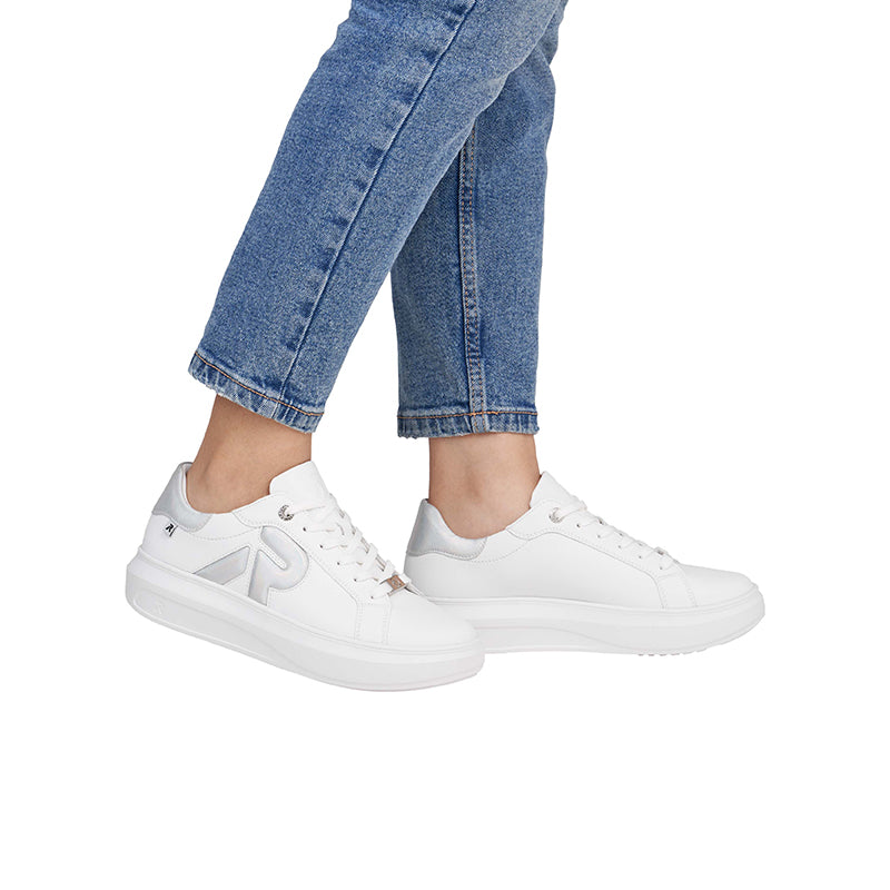 White leather lace-up sneakers on model with cropped jeans