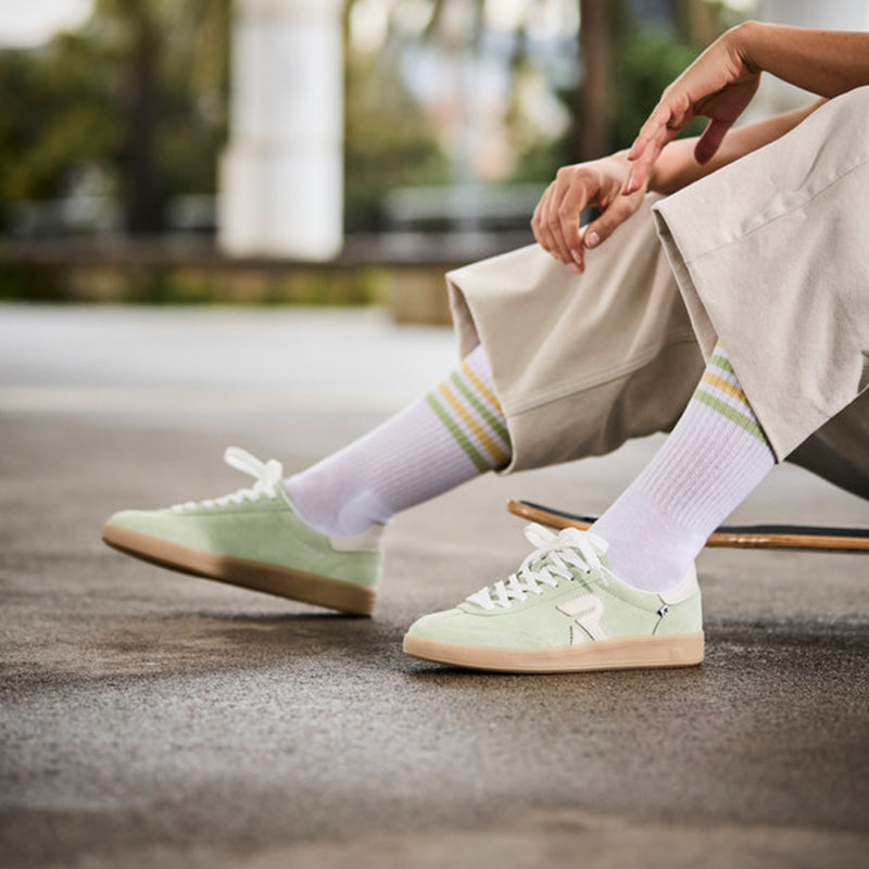 Mint and white lace-up sneakers with gum sole and striped socks.