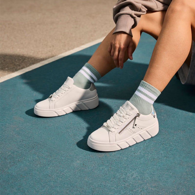 White low-top sneakers with front zip and white rubber sole, with striped socks