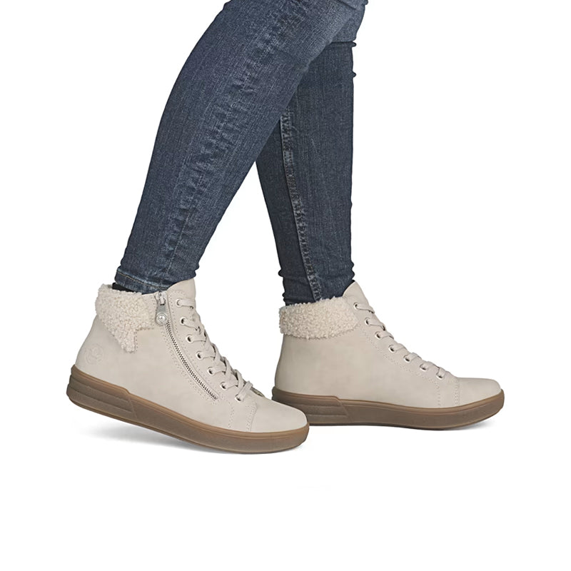 Beige ankle boots with lace-up front, sherpa lining, worn with blue jeans