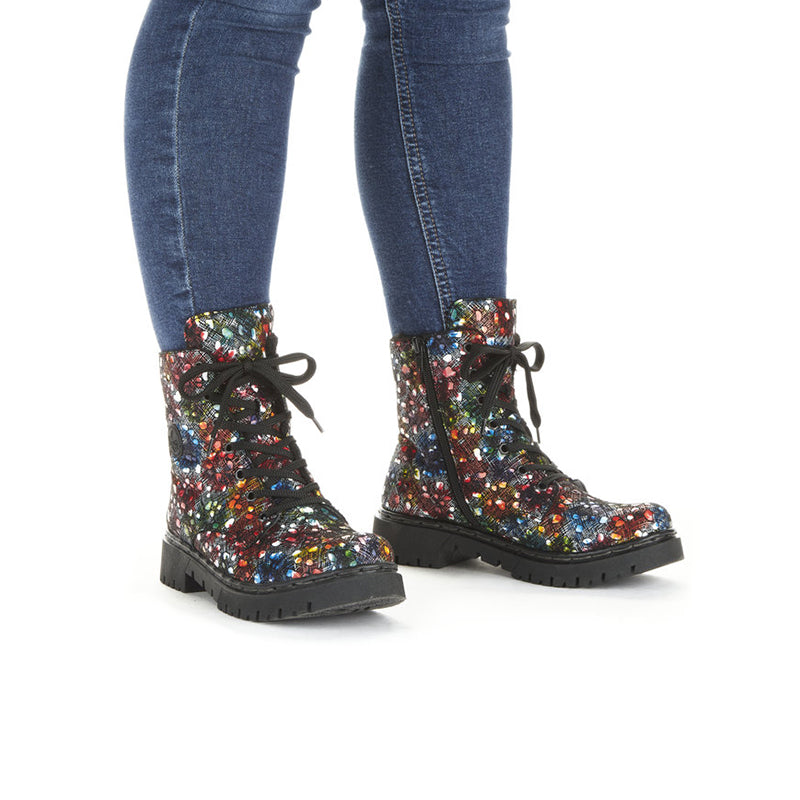 Multicolor sequin lace-up ankle boots on feet with dark chunky tread soles
