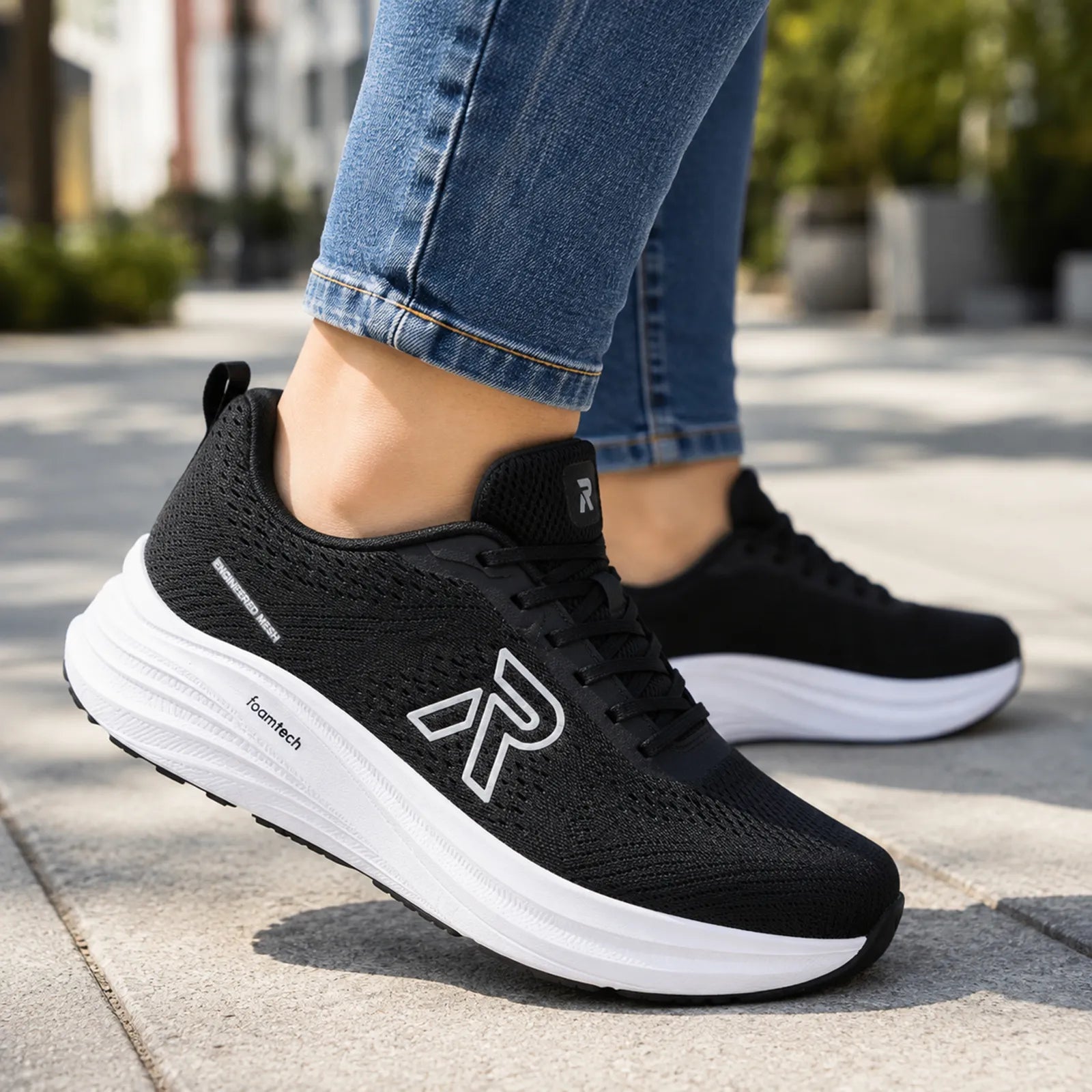 Black Rieker sneakers with white soles, mesh upper, lace-up front and side logo